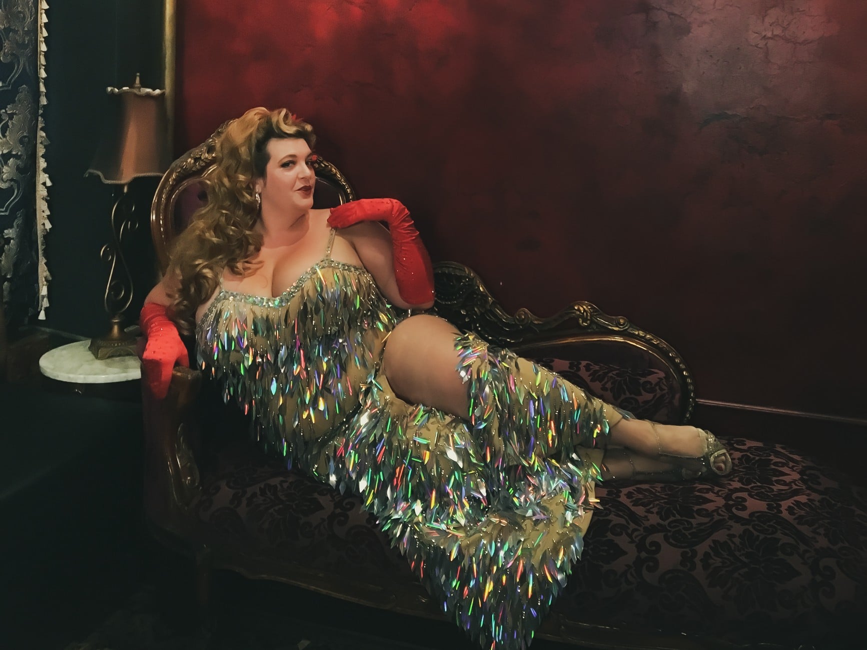 Image shows Jezebel reclining on a chaise in a sparkly silver dres and smiling into the camera above the title "26 Gifts For Traveling Showgirls and Burlesque Dancers"