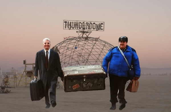 Image shows a badly Photoshopped collage of Steve Martin & John Candy wearing costumes from their roles in Planes, Trains & Automobiles, walking in front of Mad Max's Thunderdome.