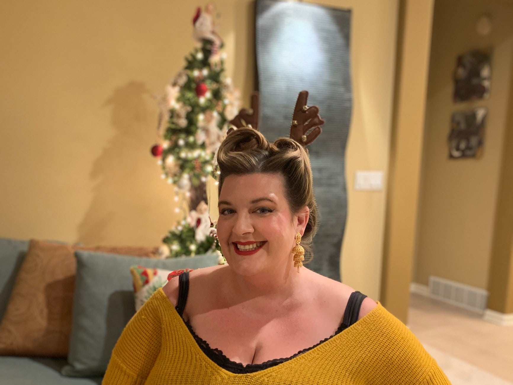 Jezebel is smiling into the camera wearing reindeer ears.